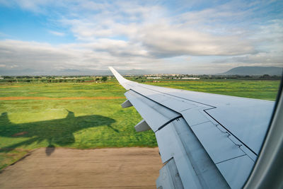 Airplane flying over landscape against sky