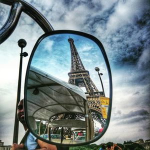 Close-up of ferris wheel against cloudy sky