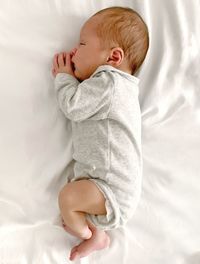 High angle view of baby lying on bed
