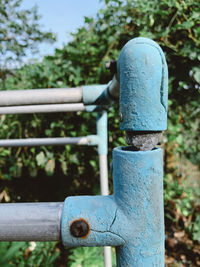 Close-up of rusty metal fence against blue sky