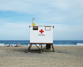 Lifeguard hut at beach against sky