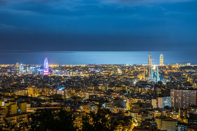 High angle view of illuminated buildings against sky at night