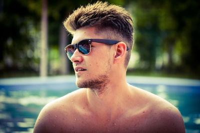 Shirtless man wearing sunglasses in swimming pool