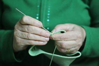 Midsection of woman knitting wool