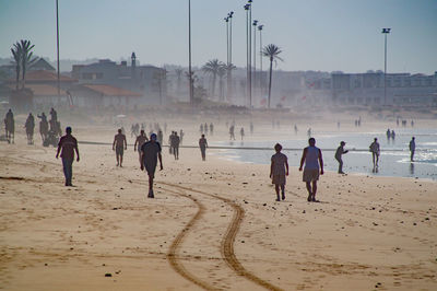 People at beach against sky