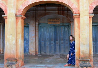 Portrait of woman standing at entrance of building
