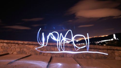 Close-up of illuminated lights against sky at night