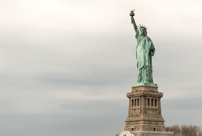 Low angle view of statue of liberty against sky