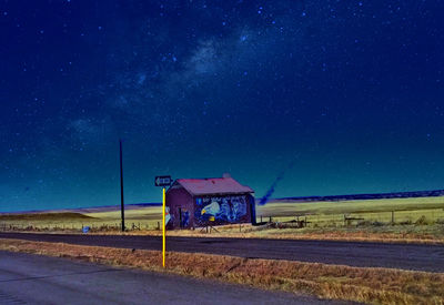 Road sign against clear sky at night