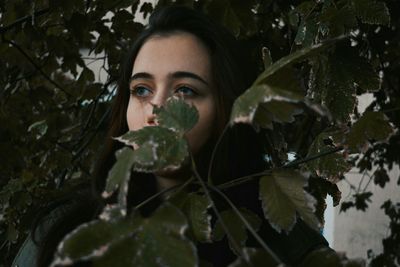 Thoughtful young woman amidst branches