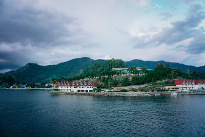 Scenic view of sea by buildings against sky