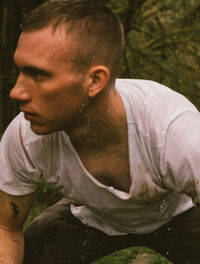 Young man looking away while standing in water