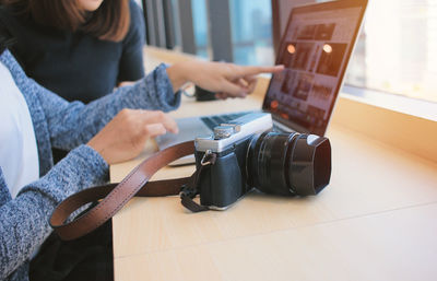 Woman photographing with smart phone on table