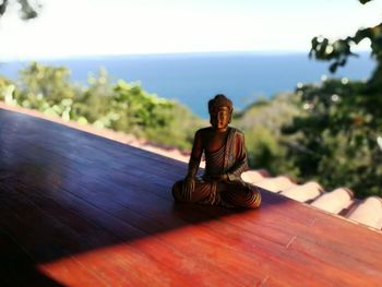 Statue of buddha sitting against sky