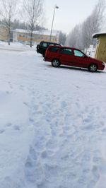 Car on snow field against sky