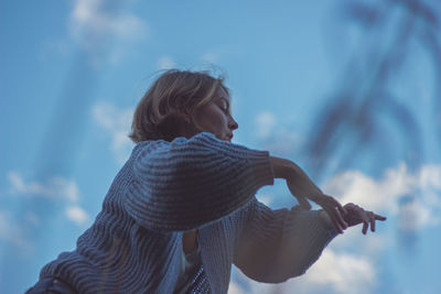 Side view of woman standing against sky during winter