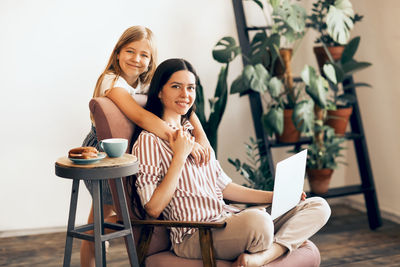 Portrait of mother and daughter at home