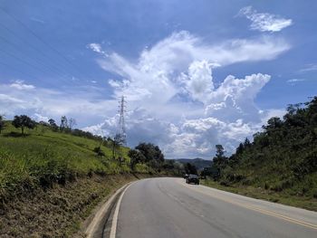 Road amidst trees against sky