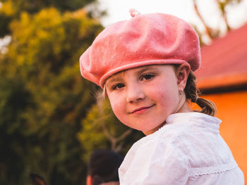 Portrait of smiling girl wearing flat cap against trees