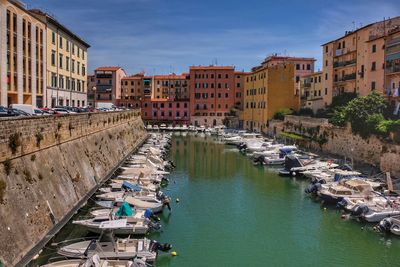 Canal amidst buildings against sky