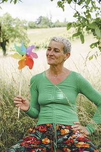 Portrait of woman with red ribbons on field