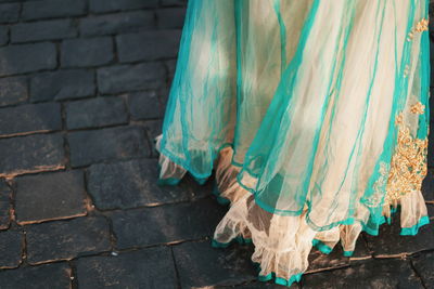 Low section of women standing on cobblestone street