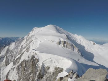 Scenic view of snowcapped mountains against clear blue sky