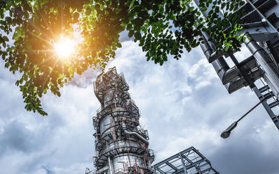 Low angle view of trees and building against sky