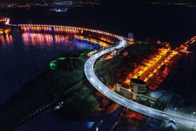 High angle view of illuminated bridge over city at night