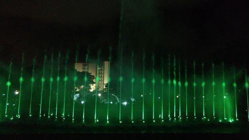 Illuminated factory against sky at night