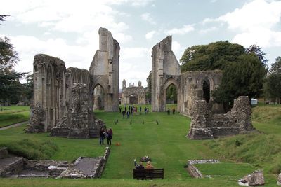 Tourists at cemetery against sky