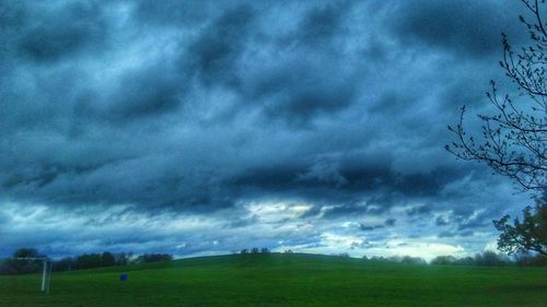 Scenic view of storm clouds over field