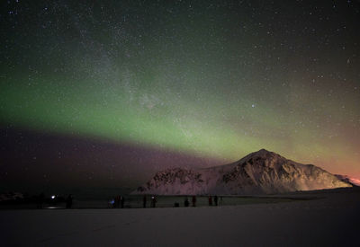 Scenic view of snowcapped mountains against sky at night