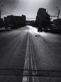 Cars on street in city against sky