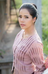 Portrait of woman standing by railing on staircase