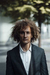 Sunlight on serious businessman with curly hair