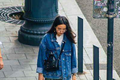 Full length of woman standing against wall in city