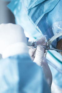 Cropped hand of doctor operating patient during knee surgery
