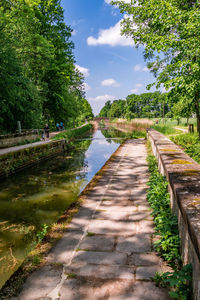 Footpath by river against sky