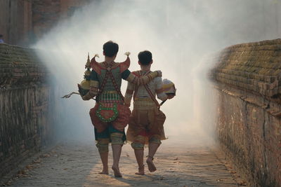 Rear view of people walking on rock