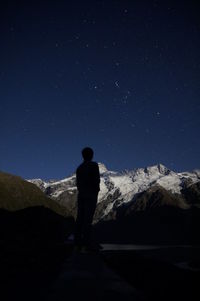 Rear view of silhouette man standing on landscape against clear sky