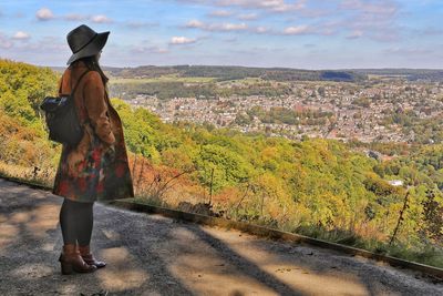 Rear view of woman standing on landscape against sky