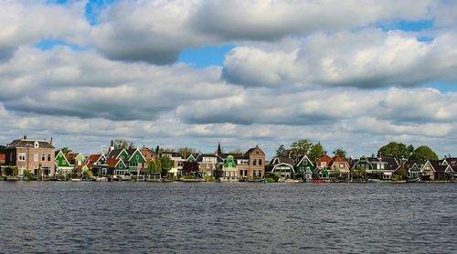 Houses by sea against sky