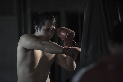 Shirtless man boxing in ring