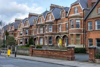 Residential building by road against sky