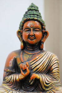 Close-up of buddha statue against white background