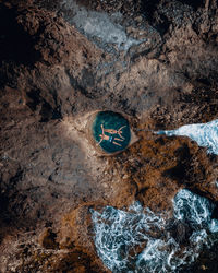 High angle view of arrow sign on rock