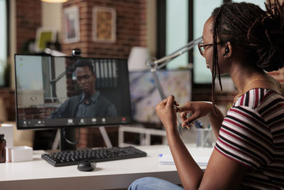 Side view of young woman using laptop