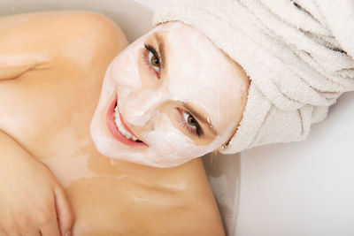 Portrait of young woman taking bath in bathroom at home