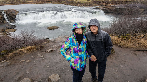 Couple standing against waterfall